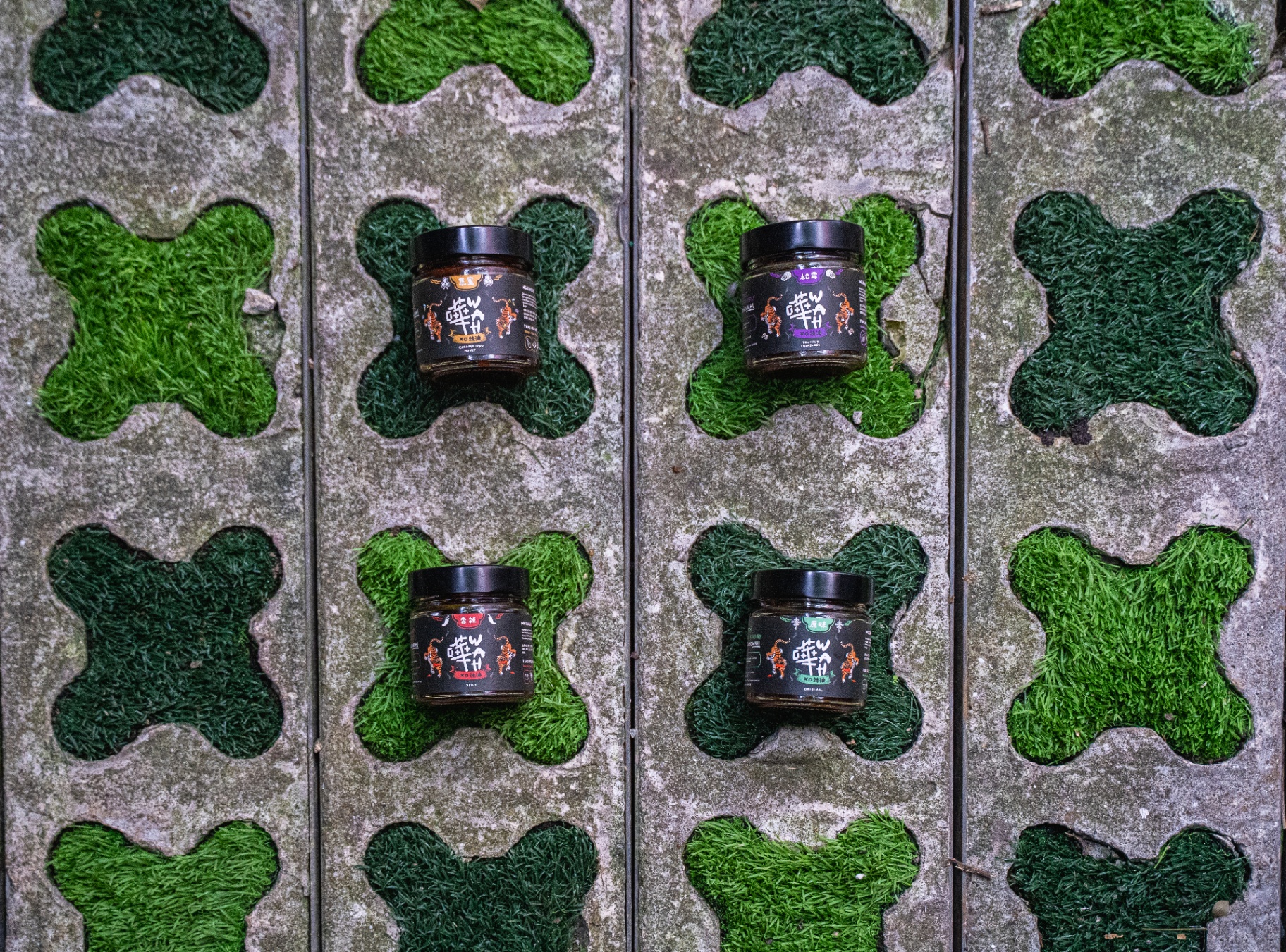 The four WAH XO sauce jars on grass-paved tiles